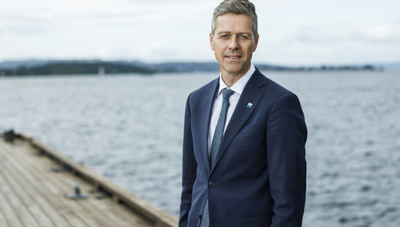 Knut Arild Hareide iført dress på brygga med sjø i bakgrunnen