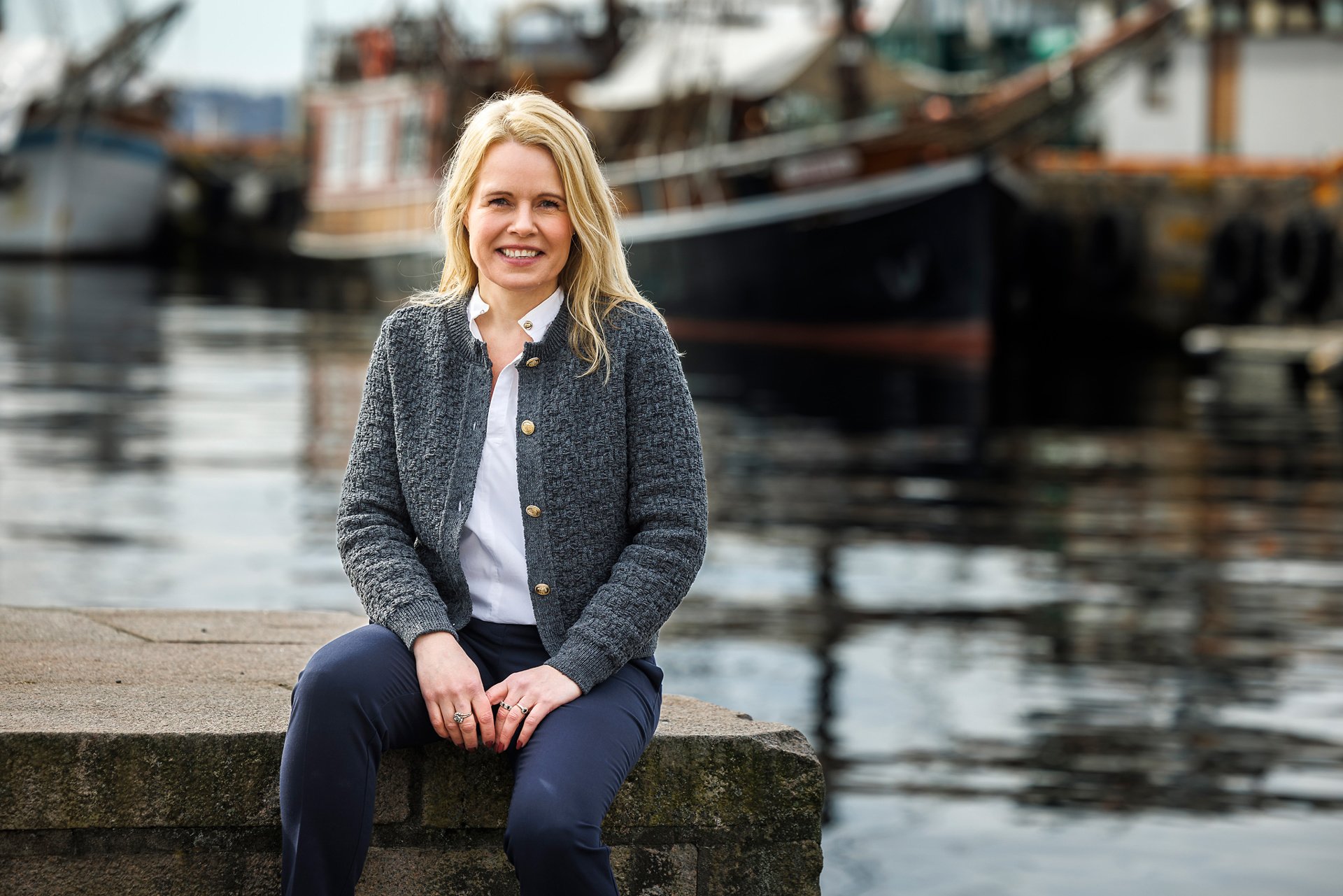 portrett av Karin Gjerløw Høidahl utendørs med en båt i bakgrunnen, 