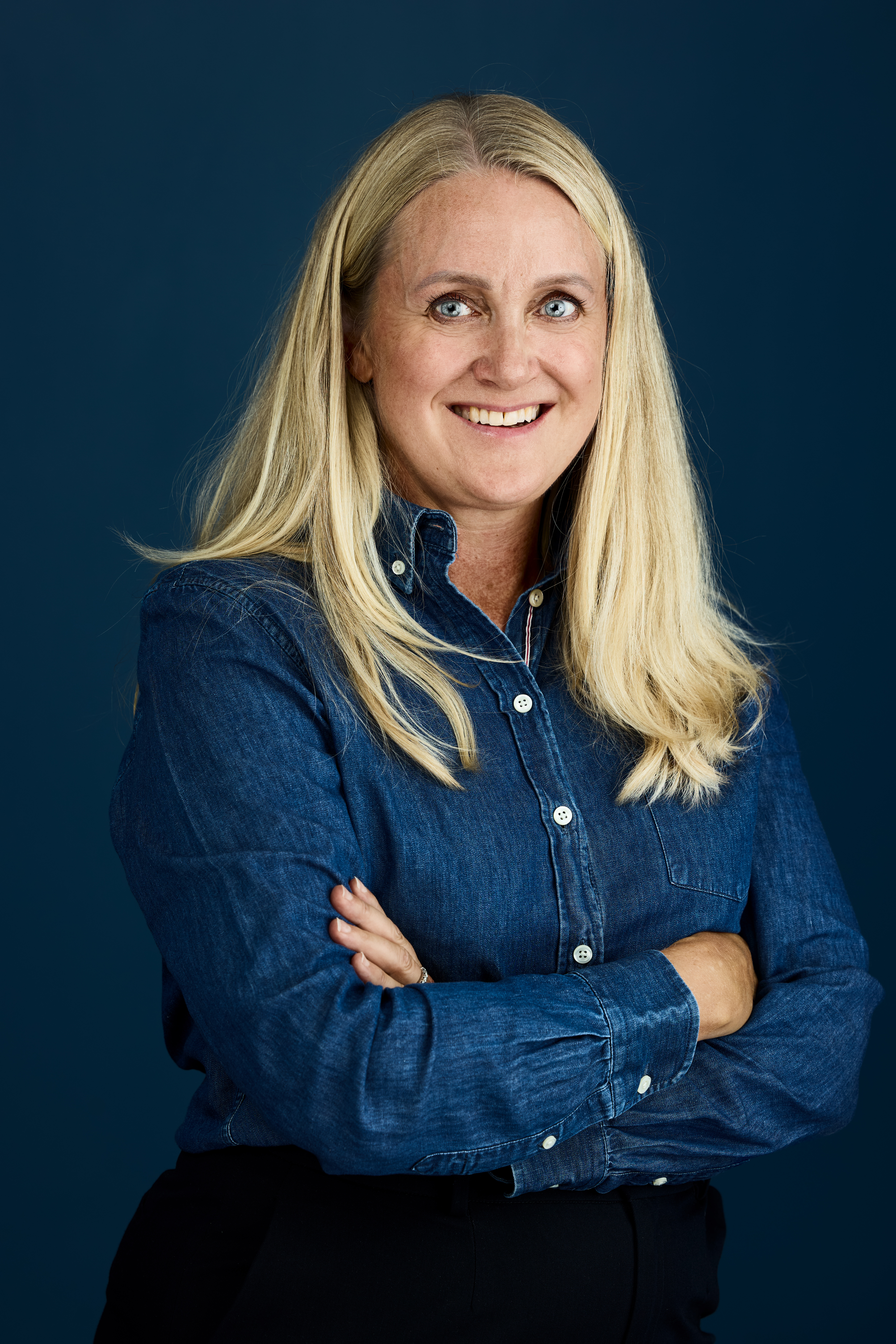 Portrett av Christine Wiig mot en mørkblå bakgrunn. 