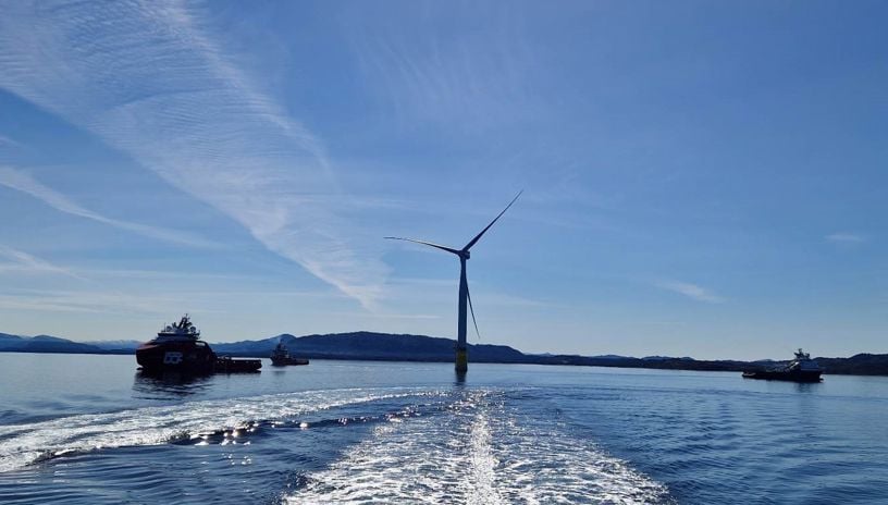 fra hywind tampen, to offshoreskip og en vindturbin i motlys