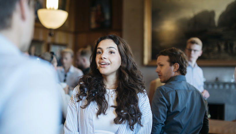 bilde fra et studentarrangement fra maritime trainee, med en kvinne med brunt, bølgete hår i fokus 