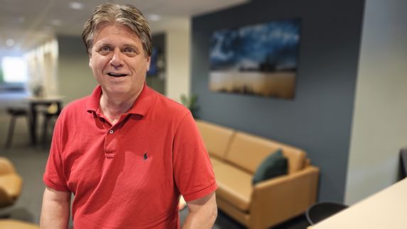 Nils Einar Steinstø i Fikse Næringsforening iført rød t-skjorte i kontorlokale 