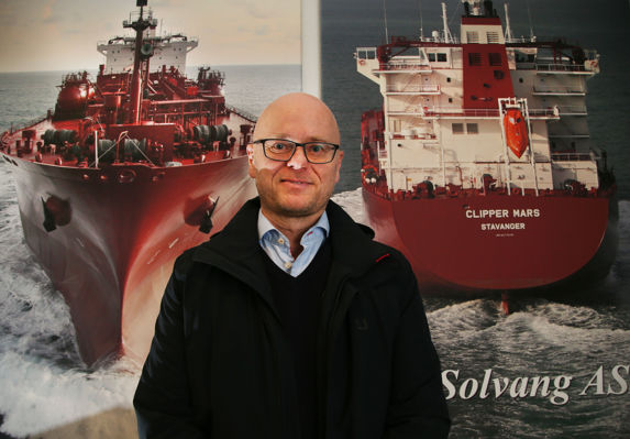 portrett av edvin endresen i Solvang foran en vegg med to store, røde skip 