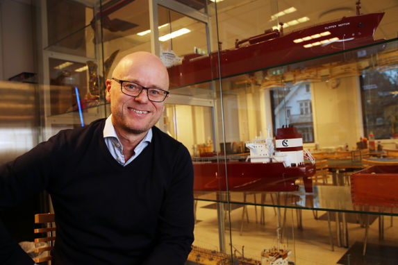 alt="Edvin Endresen leder Solvang ASA i Stavanger, her avbildet foran en vegg med skipsmodeller. Foto: Håvard Solerød "