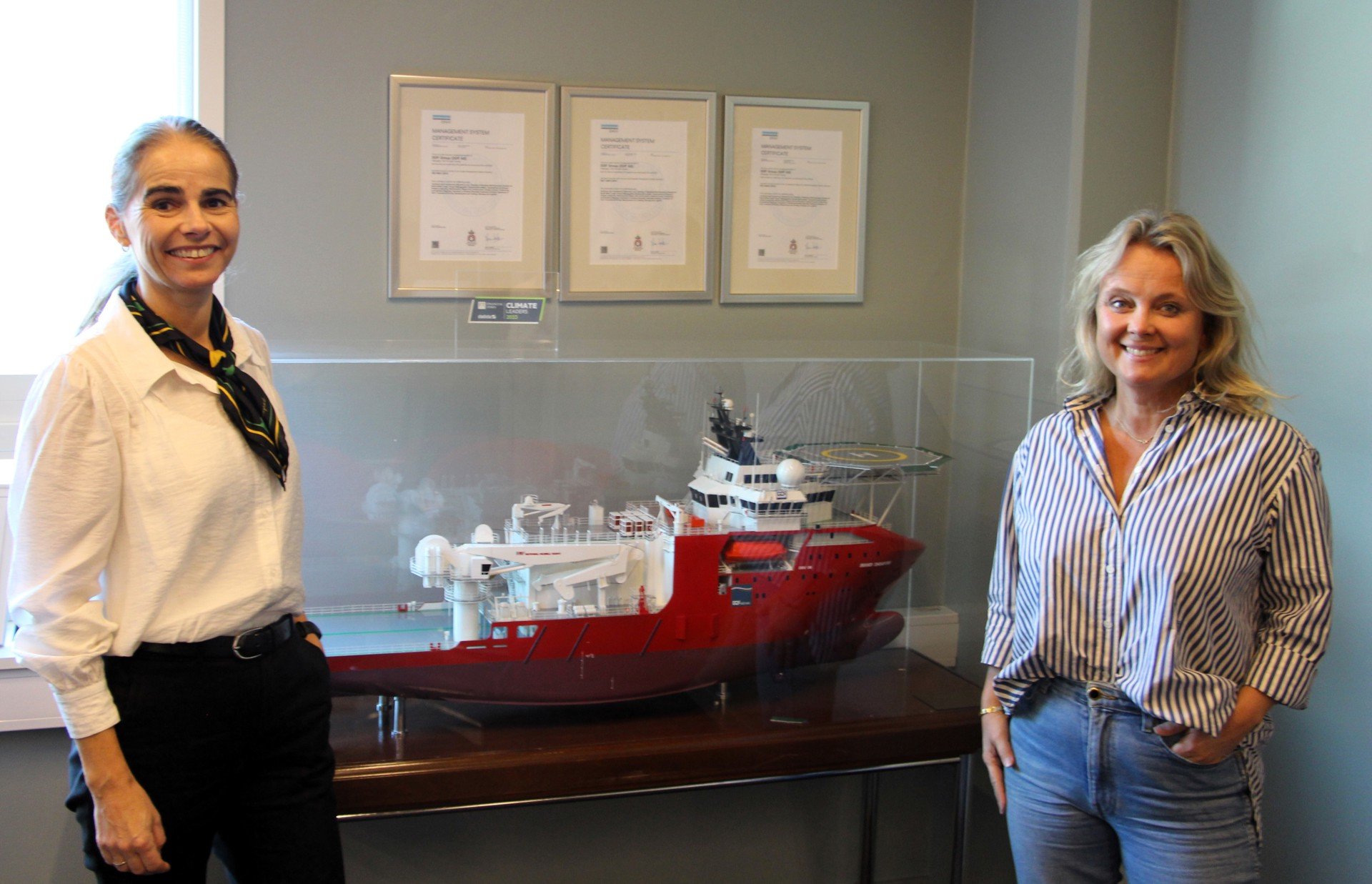 Toril Træen og Marianne Møgster i DOF foran en skipsmodell 